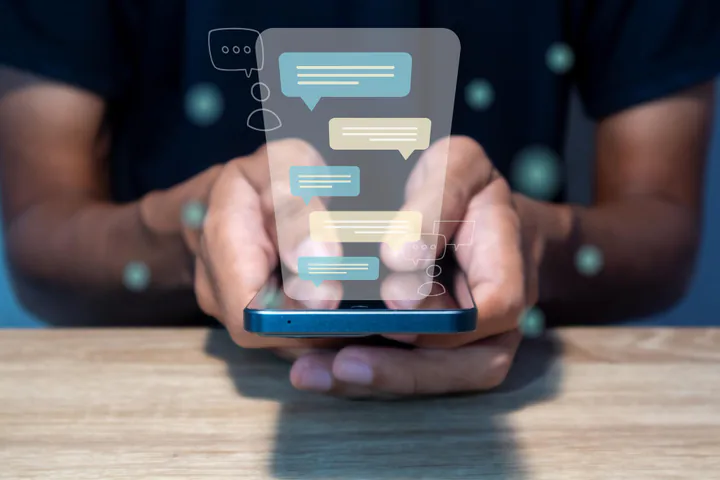 Mãos segurando um celular com mensagens de atendimento